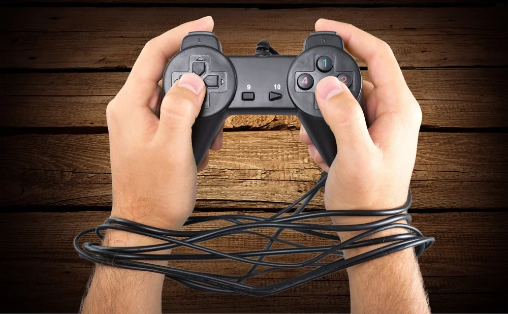 Picture of hands being bound by playstation controller cords